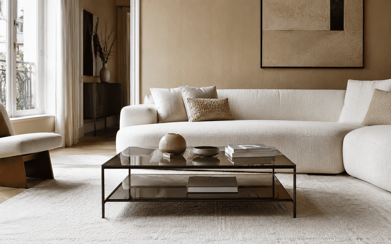Table basse en verre fumé dans un petit salon chic avec canapé clair et structure fine