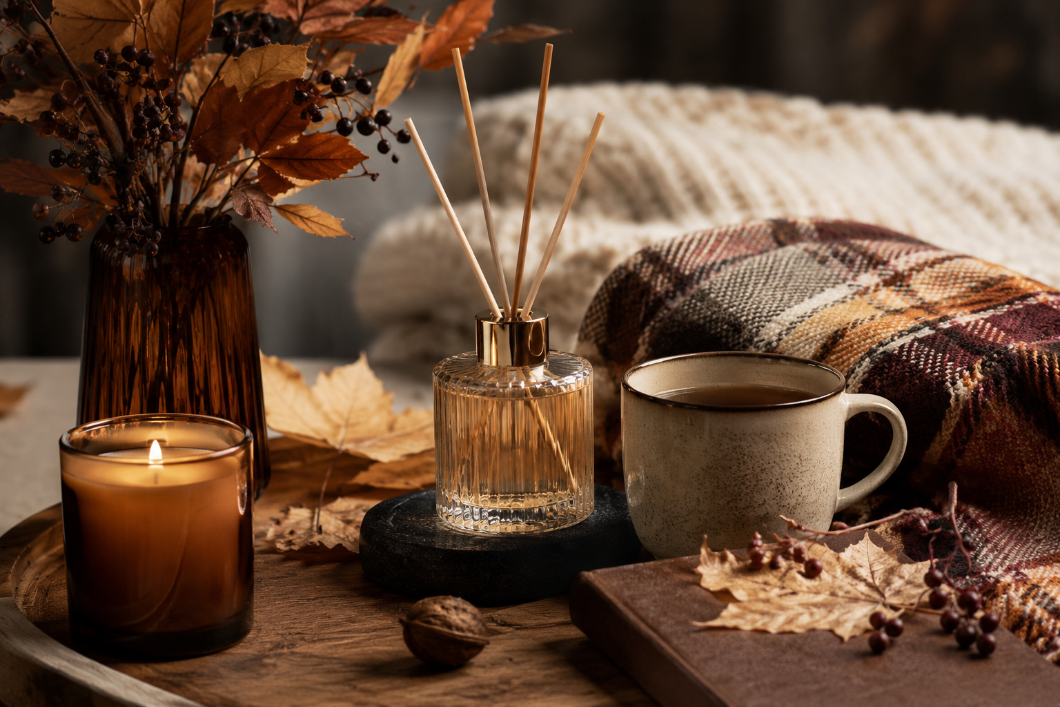 Nature morte automnale avec diffuseur, bougie, thé chaud et plaid cosy