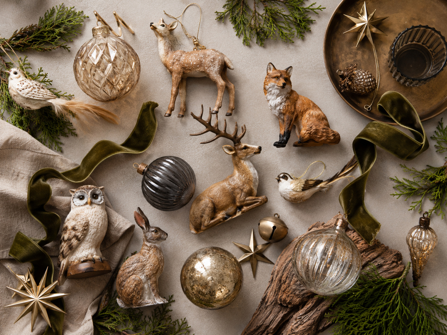Composition de décorations animales avec renne, renard, hibou, lapin, oiseaux, velours vert et ornements en verre.