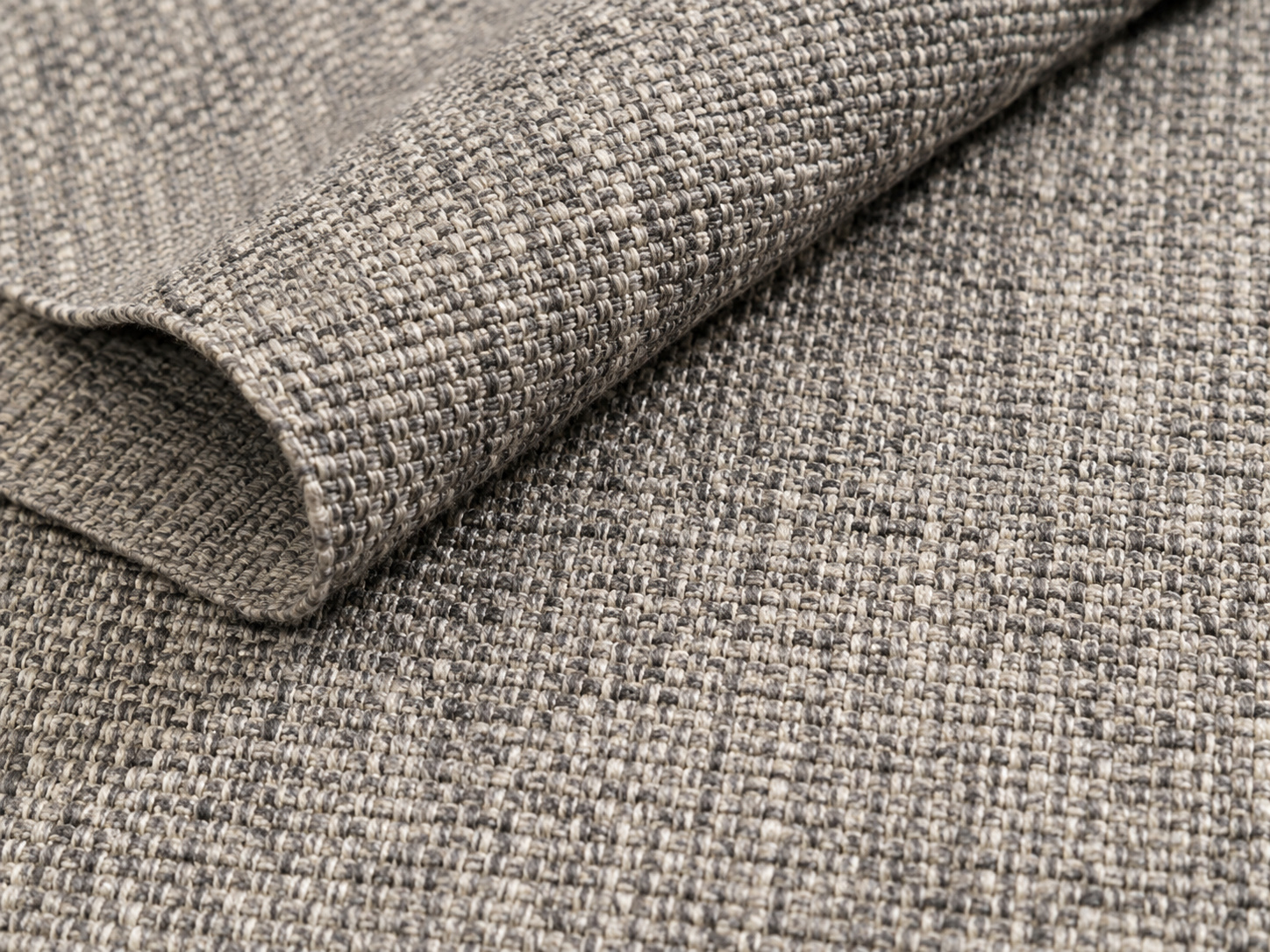 Gros plan sur un tapis en fibres synthétiques à tissage régulier et résistant.
