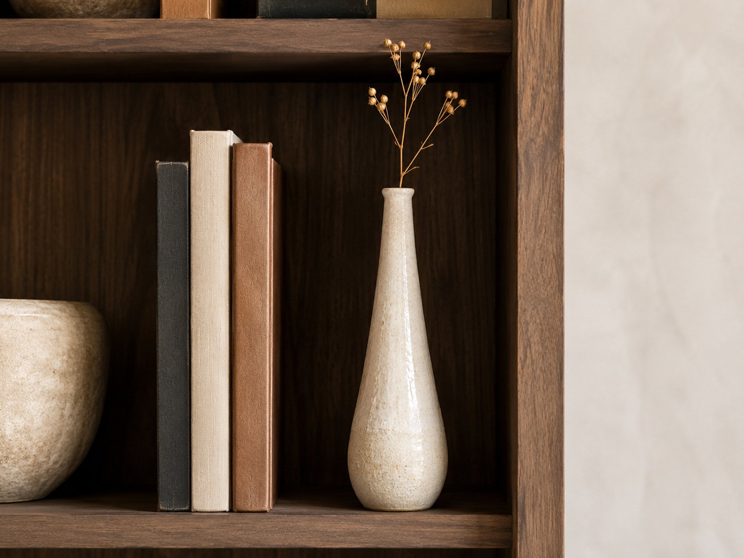 Vase décoratif posé avec quelques livres pour créer de la hauteur sur une étagère