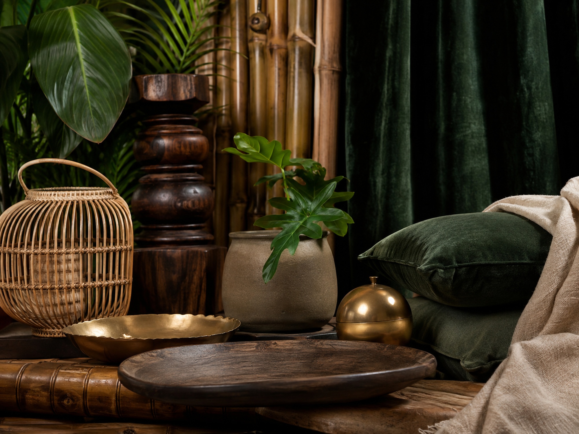 Nature morte jungle avec rotin, bambou, bois sombre, lin, laiton et céramique verte.