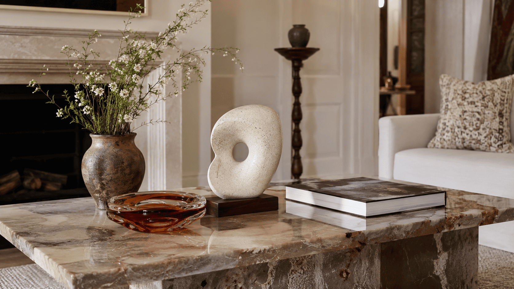 Objet décoratif décalé posé sur une table basse contemporaine avec vase et livre d'art.
