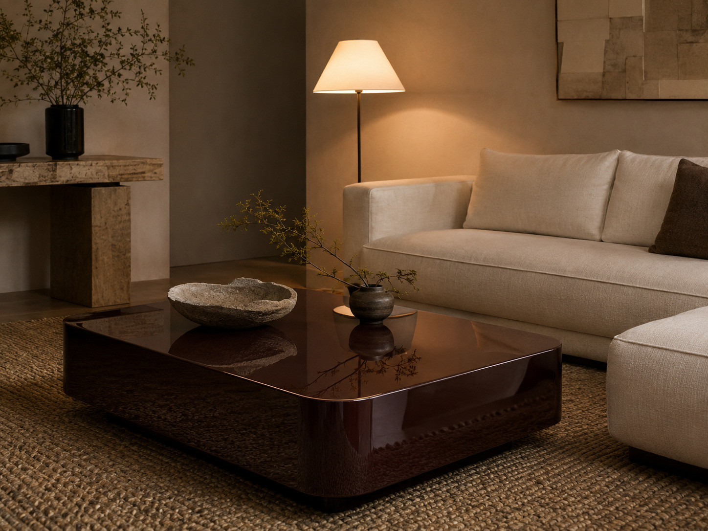 Salon chaleureux avec grande table basse bordeaux laquée, canapé crème et matières naturelles.