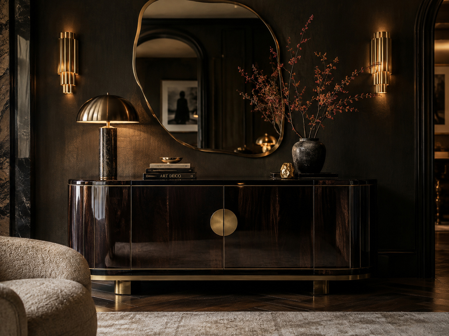Buffet sombre aux détails en laiton et miroir organique dans une ambiance Art déco contemporaine.