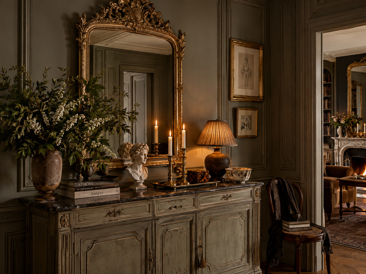 Buffet ancien patiné et grand miroir doré sculpté dans un intérieur parisien de caractère.
