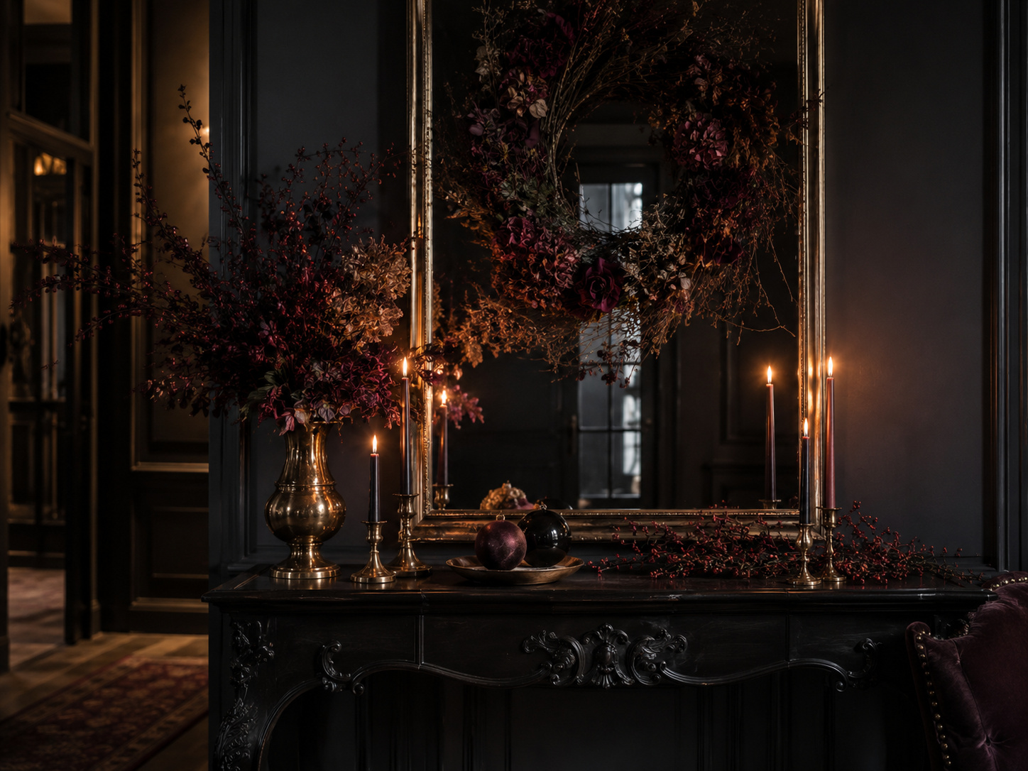 Composition gothique chic avec miroir ancien, bougies sombres, branches séchées et détails en laiton.