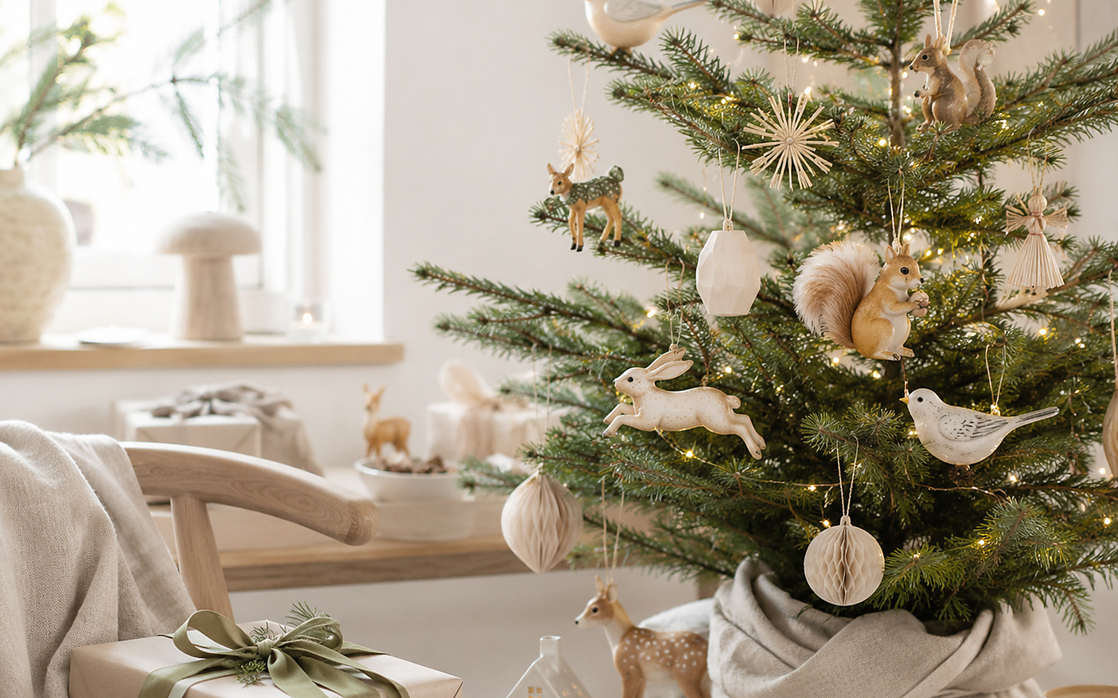 Sapin de Noël hygge décoré avec bois, matières textiles, tons ivoire et lumière chaude.