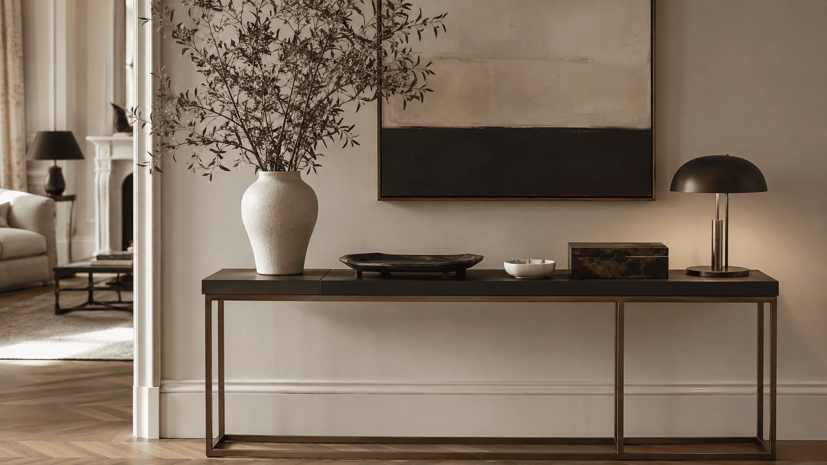 Plateau, vide-poche, petite lampe et céramique sur une console contemporaine bien organisée.