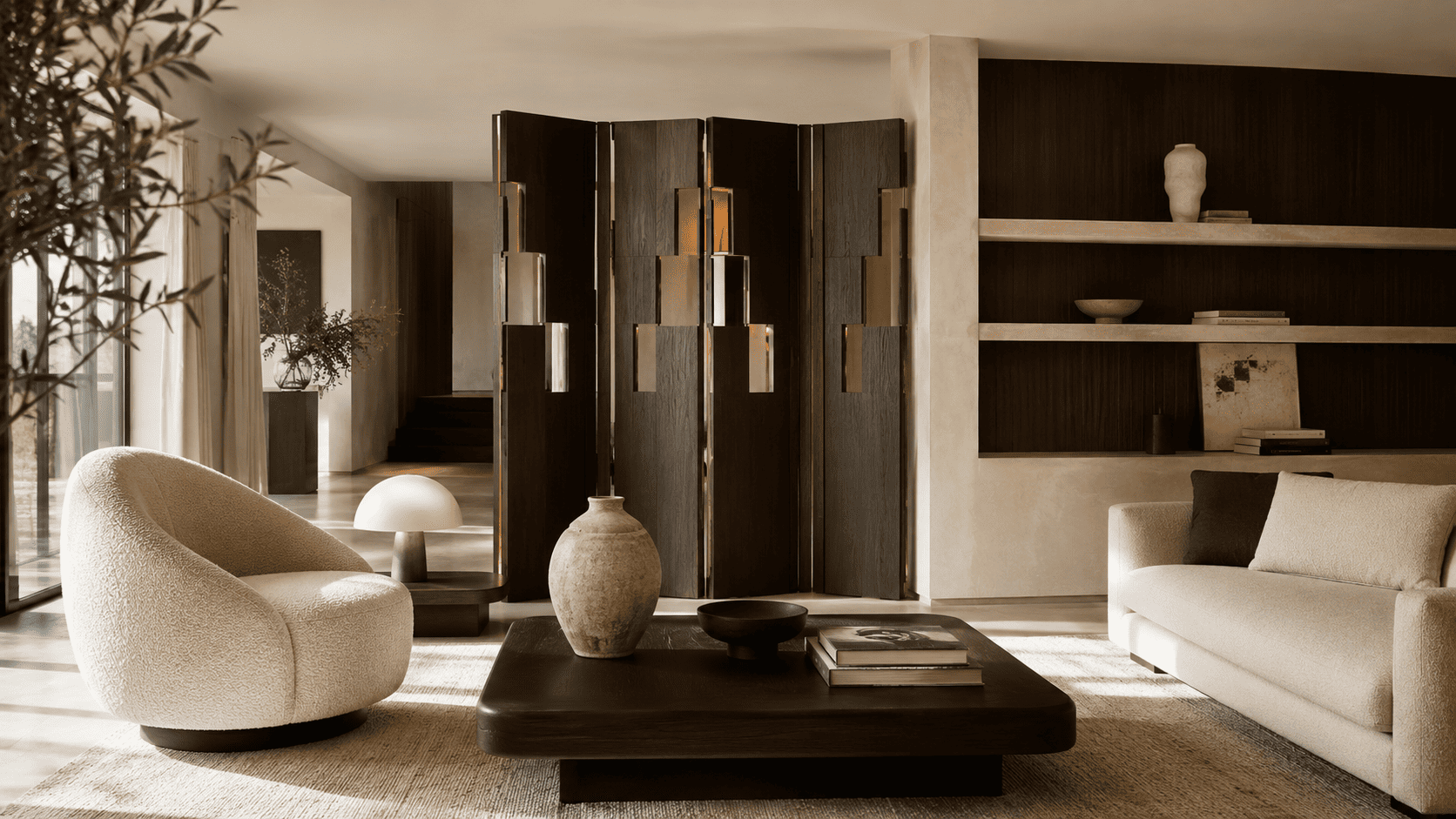 Salon contemporain avec paravent design, fauteuil texturé, lampe basse et décoration chaleureuse.