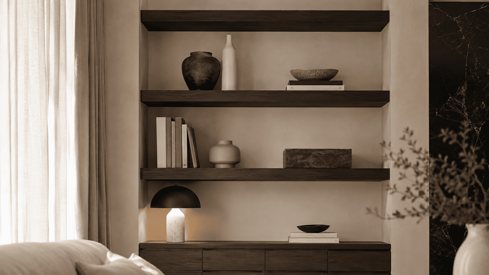 Étagère contemporaine avec livres, céramiques, boîte décorative et objets bien espacés.