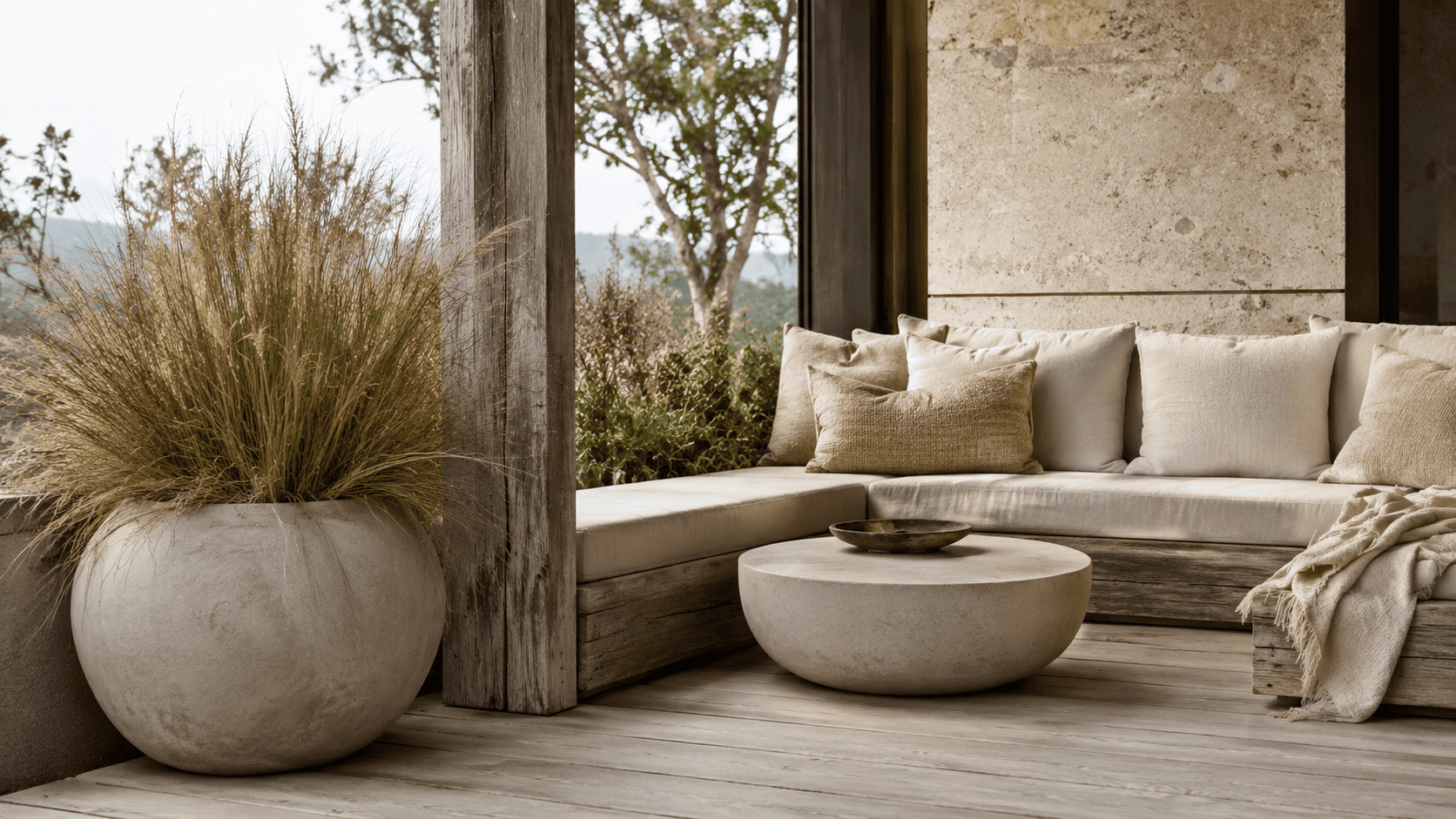 Terrasse wabi-sabi contemporaine avec bois patiné, pierre, céramique brute, plantes naturelles et ambiance apaisée.