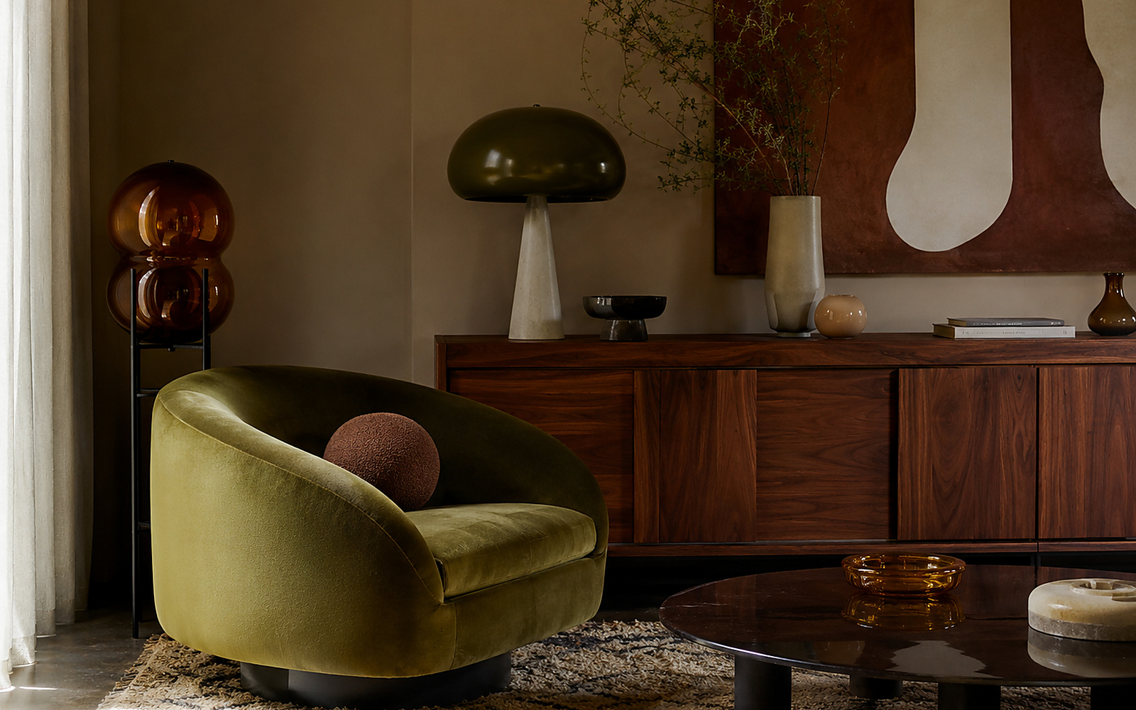 Salon inspiré des années 70 avec fauteuil olive, noyer, verre ambré et formes arrondies.